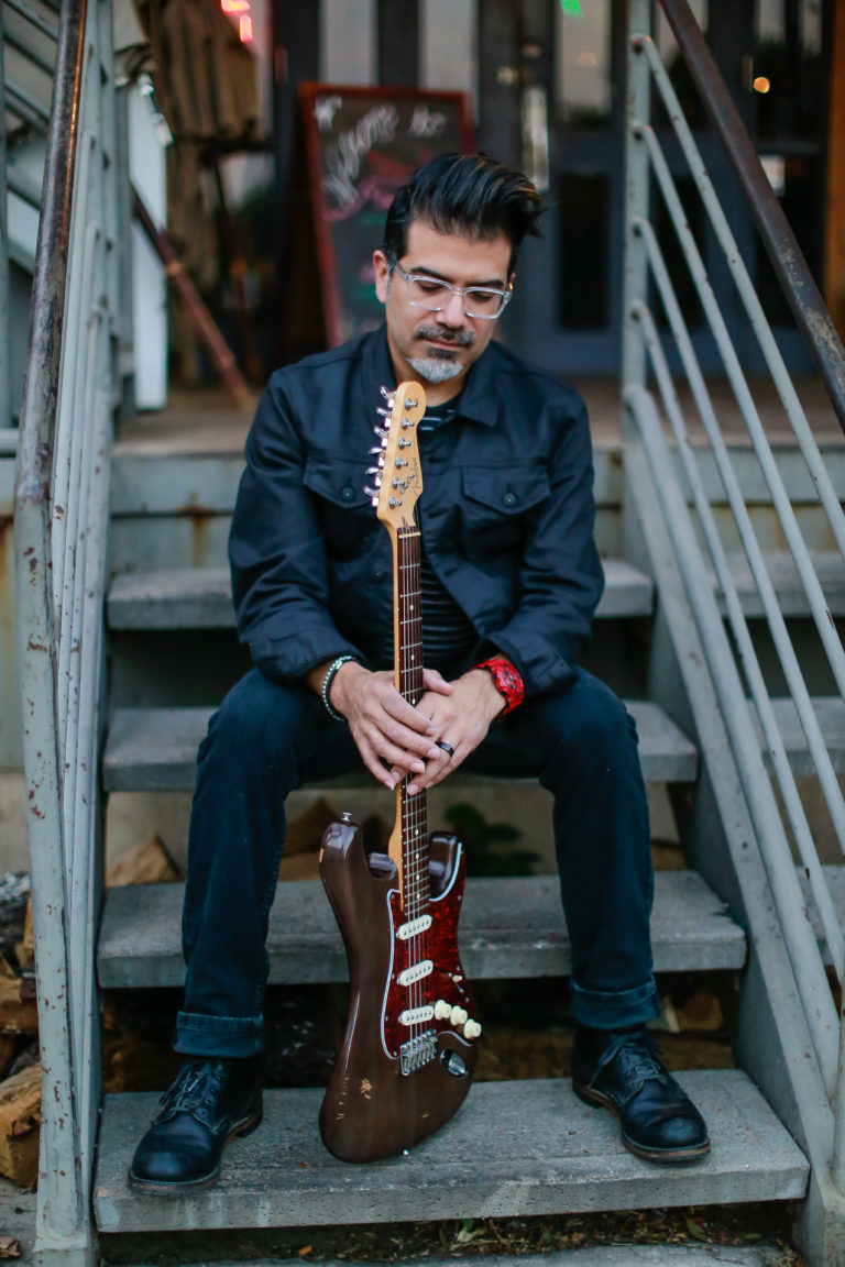 Photo of Adam Zuniga holding a guitar