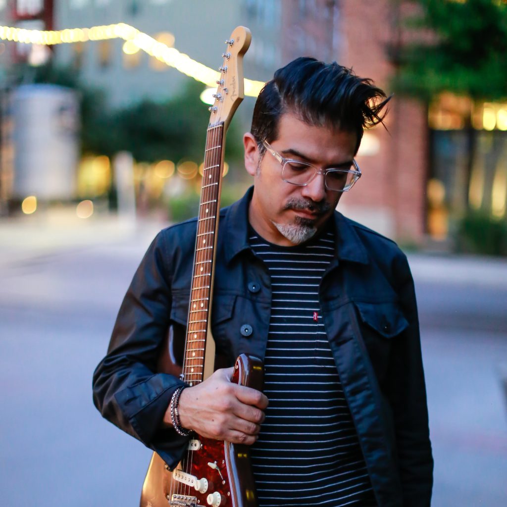 Adam holding Fender Stratocaster guitar.