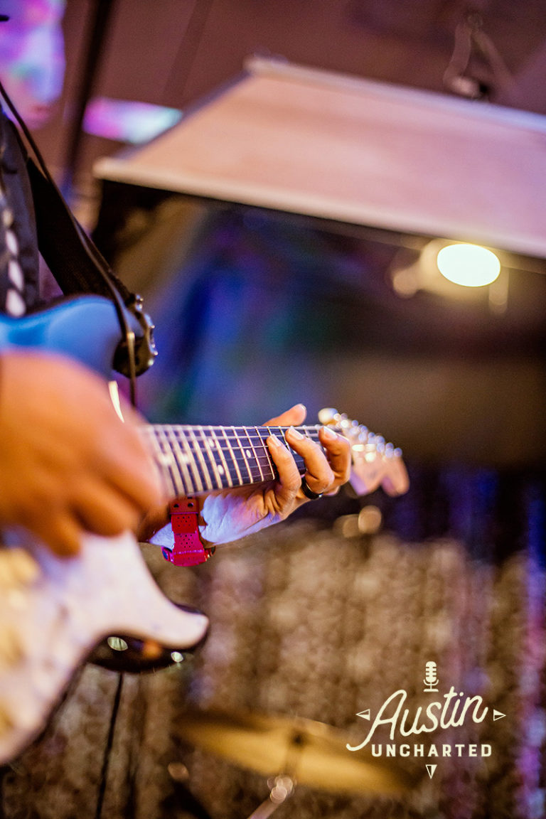 Photo depicts Adam holding the guitar.